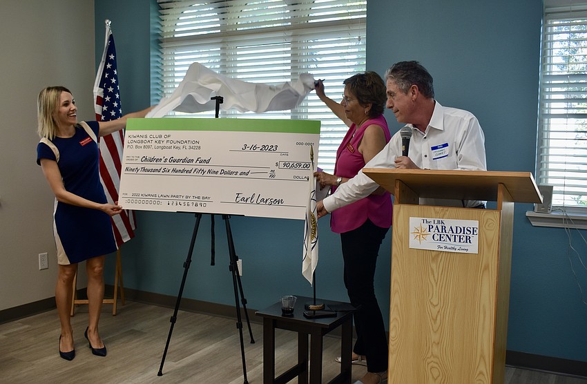 Svetlana Ivashchenko and Cynthia Craig reveal the check with Michael Garey.