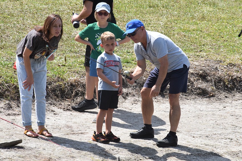 Lakewood Ranch's Danielle Gassenhofer listens carefully as her children, 8-year-old Eleanor Gassenhofer and 6-year-old Edison Gassenhofer, get advice on how to cast from Robert LaVopa, a member of the Lakewood Ranch Angler's Club.