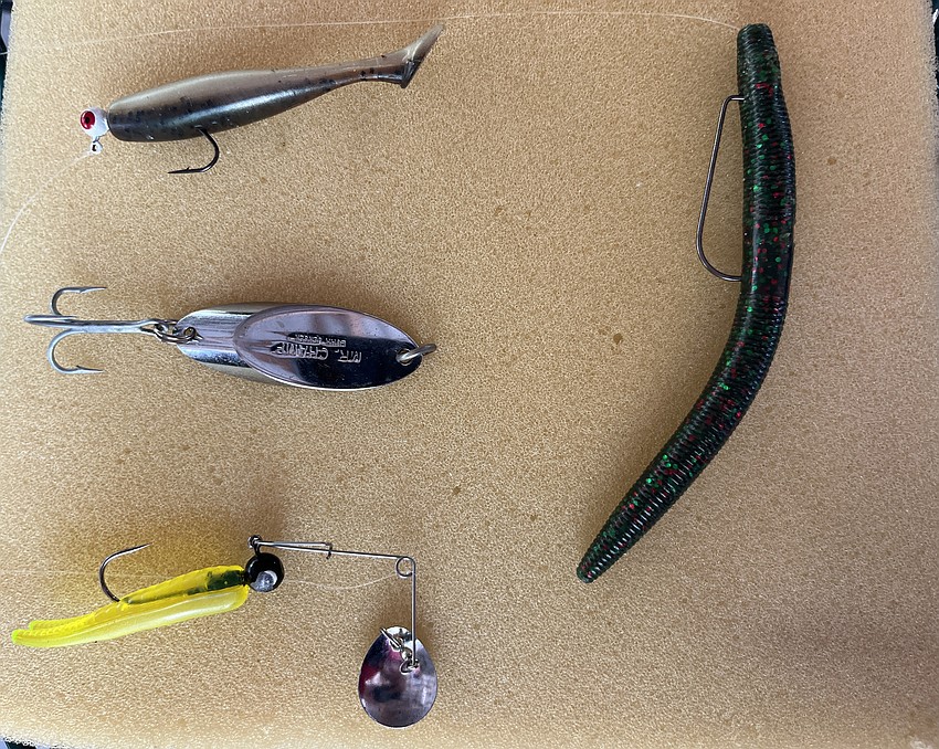 There are several types of lures to use when fishing including a jig and minnow (top left), spoon (center), spinner bait (bottom left) and a Texas rigged plastic worm (right).