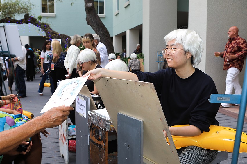 Andy Warhol students sketch caricatures for guests.