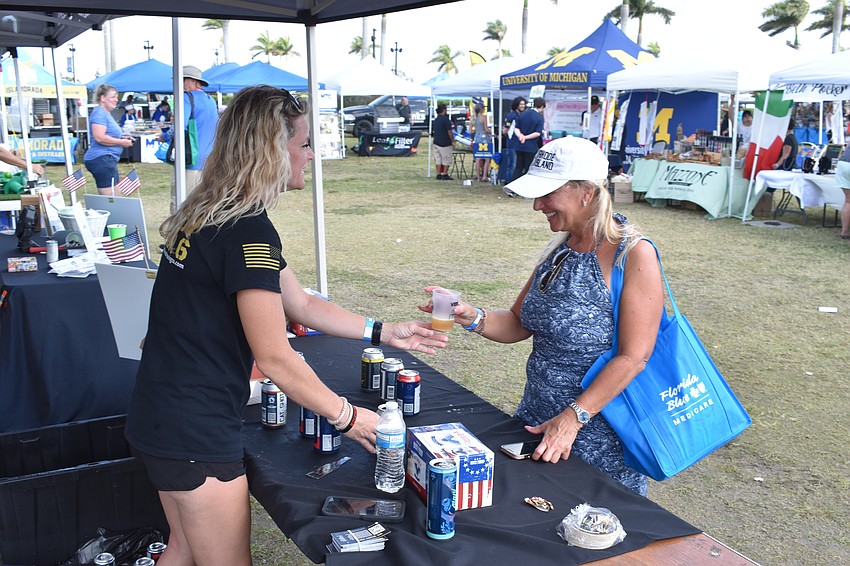 Keisha Boyd of Armed Forces Brewing Co. offers a brew to Sarasota's Pam Hogan.