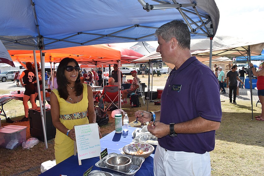 Jill Michel of Vermonti Cannoli offers a cannoli sample to Dennis Németh of The Love Vault.