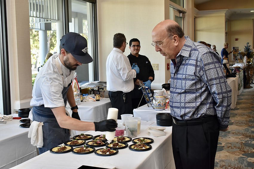 Aaron Kulzer puts the finishing touches on Mar Vista's braised brisket tacos as Paul Gold waits patiently.