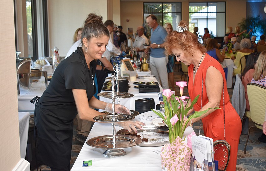 Rachel Hagan replenishes the sweets from Harry's Continental Kitchens as Debbi Mettlow takes a sample.
