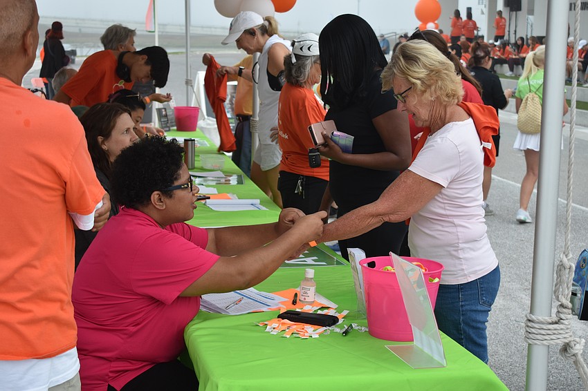 Geralde Mack provides a wristband to Joan Hartmann.