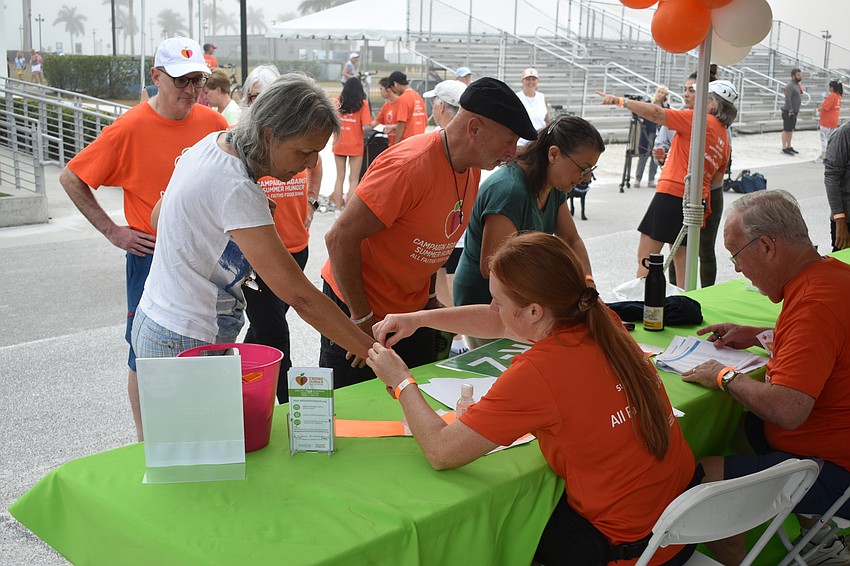 Sandra McCray receives a wristband from volunteer Leslie Franczek.