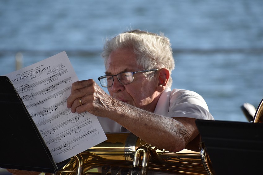Tuba player Bill Milner studies the next selection with Kingfisher Lake in the background.