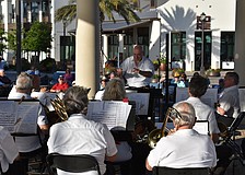 Conductor Joe Martinez leads the Lakewood Ranch Wind Ensemble with Waterside Place in the background. Could the ensemble be playing at the new Rangeland High theater?