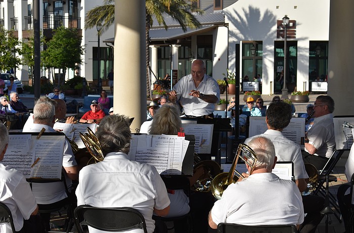Conductor Joe Martinez leads the Lakewood Ranch Wind Ensemble with Waterside Place in the background. Could the ensemble be playing at the new Rangeland High theater?