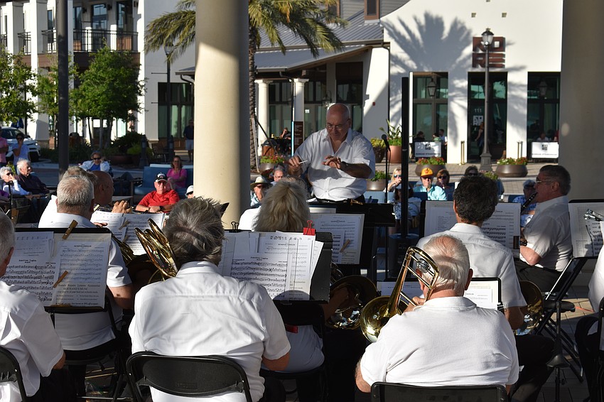 Conductor Joe Martinez leads the Lakewood Ranch Wind Ensemble with Waterside Place in the background.