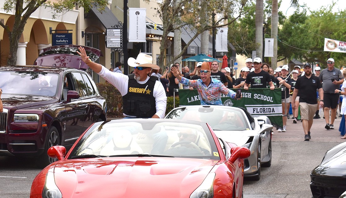 Manatee County Sheriff Rick Wells rides in a Ferrari during the 2023 Exotic Car Show on Main Street at Lakewood Ranch March 25. Legendary circus performer Bello Nock follows in the next car.