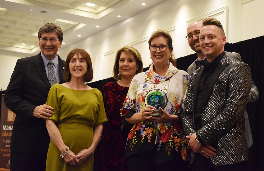 Arts advocate Vernon DeSear, Manatee Arts Education Council members Mary Glass and Dudley Leigh, Ben Jewell-Plocher and Jeramiah Bowman surprise Cynthia Saunders (center), the superintendent of the School District of Manatee County, with an award to honor her dedication to the arts in the school district.