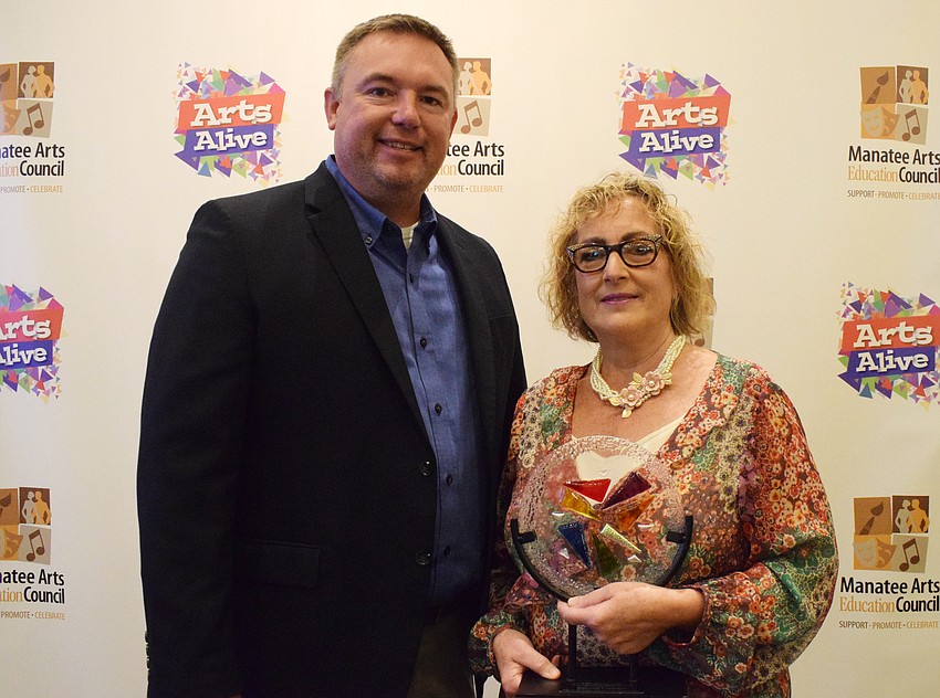 Dustin Dahlquist, the principal at Lakewood Ranch High School, congratulates theater department director Roxane Caravan on receiving the Dr. Sherry Lawrence Theatre Education Award.