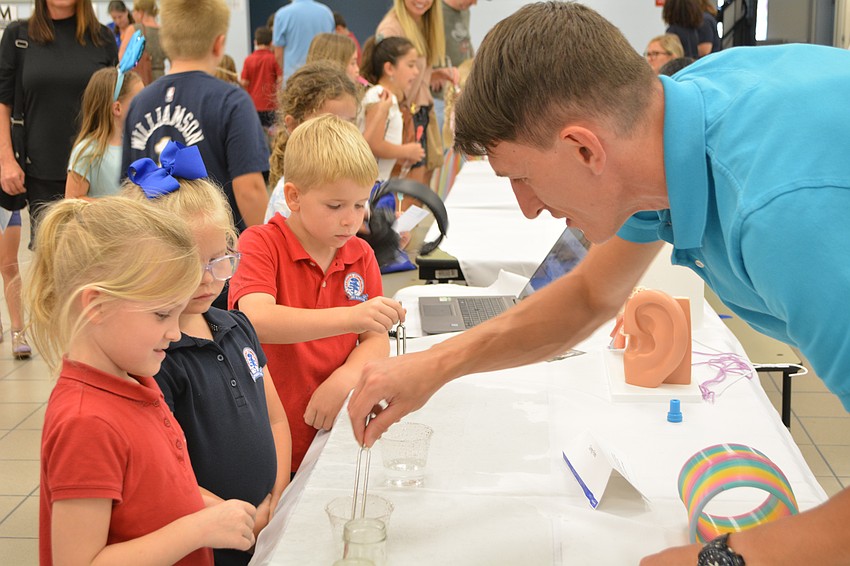 Music teacher Sergei Glushonkov demonstrates how a tuning fork works for Finnley Adamson, age 7.