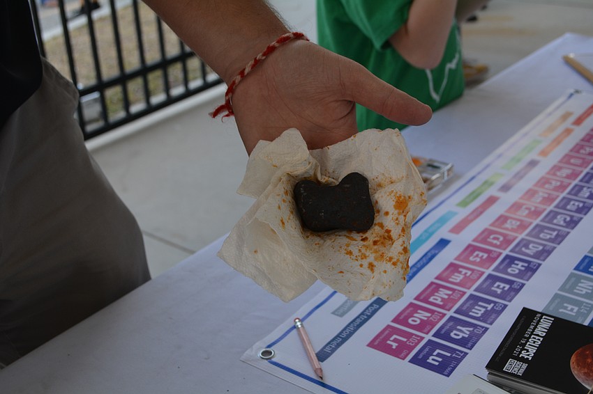 Alex Martin of the Sidewalk Science Center shows off a piece of a 4.5-billion-year-old meteorite.