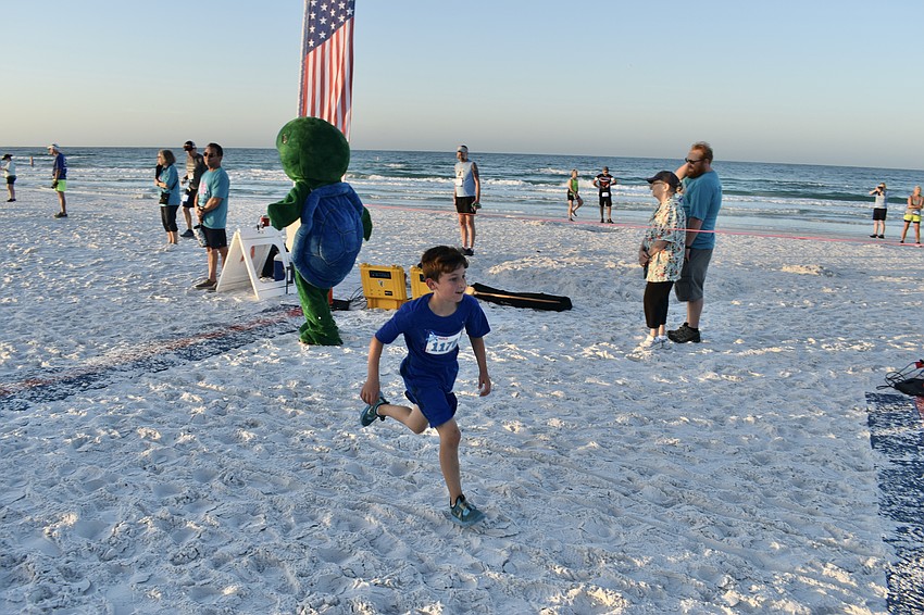 Rowan Goldrick crosses the finish line of the 1-mile race.