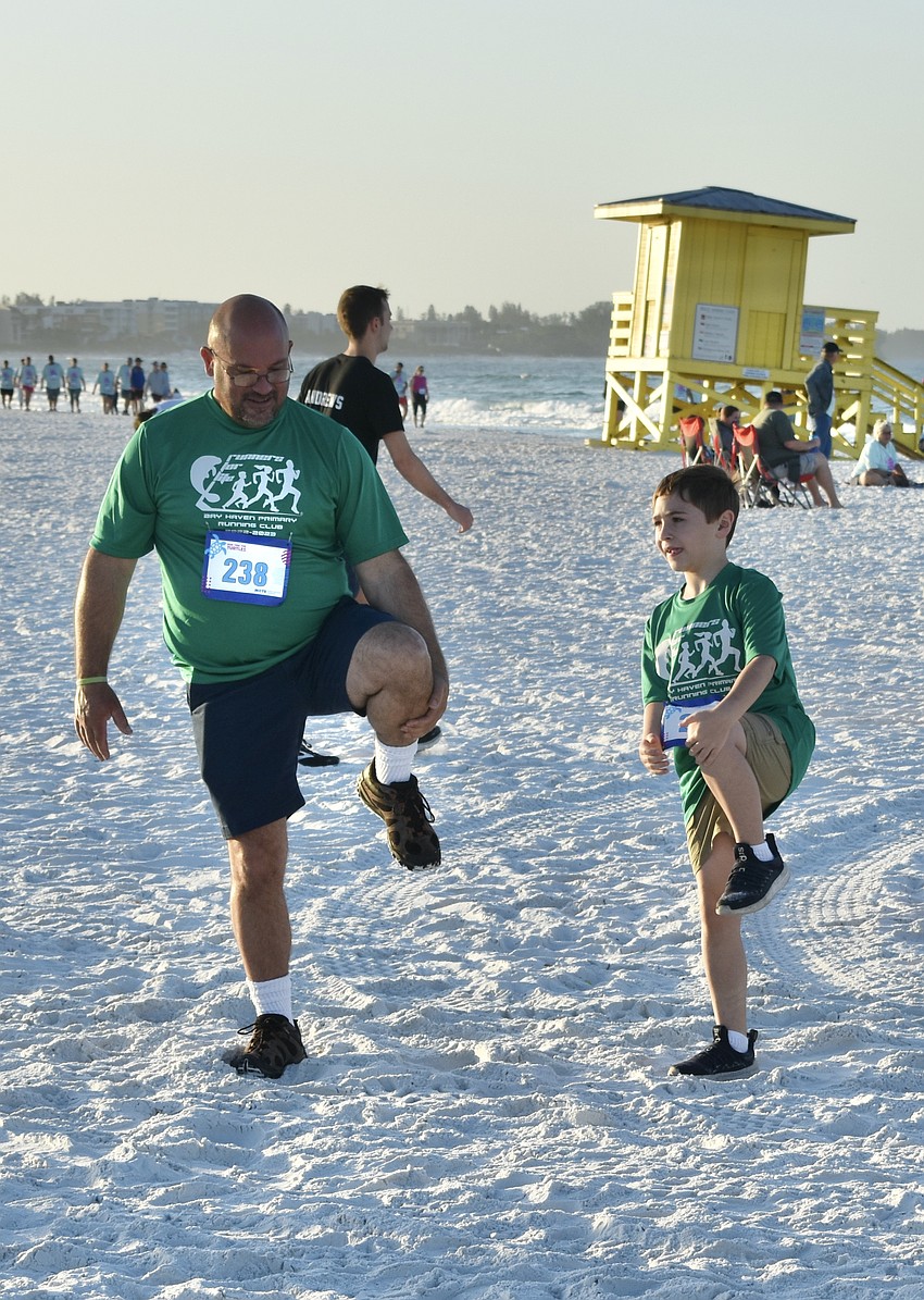 Steve Morin and 7-year-old Houlton Morin perform warm-ups before the race.