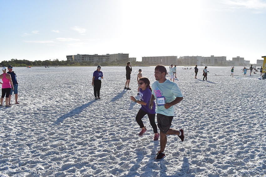 9-year-old Isabella Hurtado and Mijail Hurtado approach the finish line of the 5k race.
