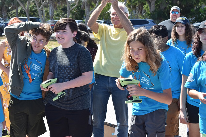 13-year-olds Drake Ouellette of the team Sord and Darshan Kolesar of the team Concorde maneuver their cars into the boat at the end of the challenge course.
