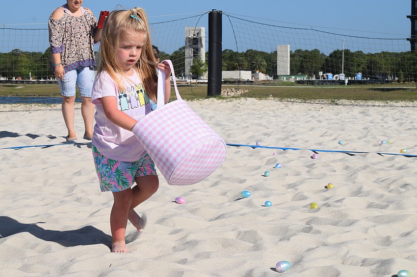 Sarasota's Cate Rizzo, who is 3, has fun finding and collecting eggs in her bag.