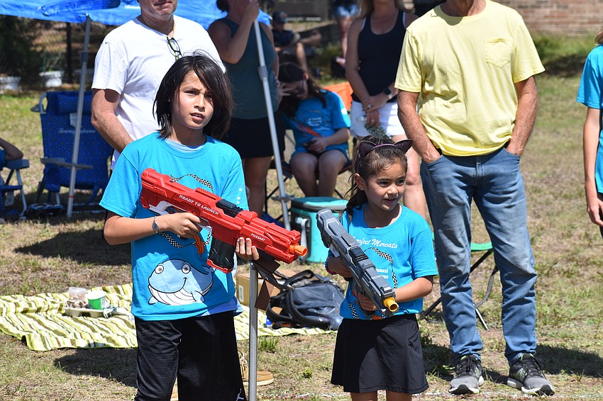 11-year-old Hayden Khuu of the Wiggly Whales and 7-year-old Charlotte Runnalls of the Purrfect Mercats helped spray cars with water guns along the obstacle course track.