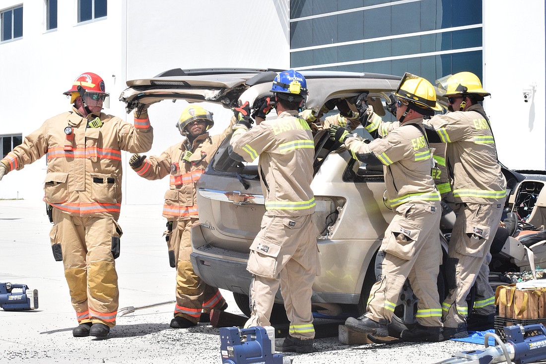 Firefighters from East Manatee Fire and Rescue and Southern Manatee Fire and Rescue work together to take the roof off a car to extricate a patient.