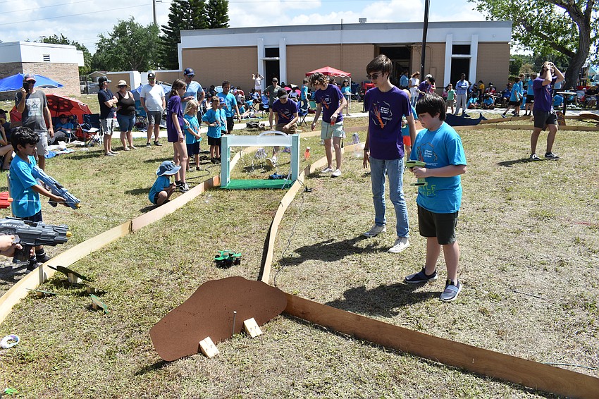 14-year-old volunteer Mason Peters and 11-year-old Noah Veverka of Turtle Troops manage a turn around the obstacle course.