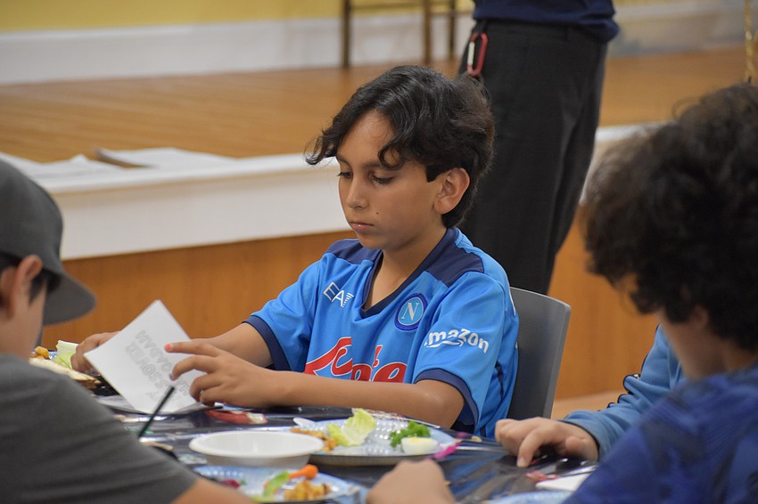 11-year-old Avi Shalev reads the Haggadah, which sets forth the order of the Passover Seder.