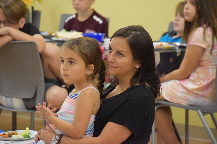 5-year-old Landry Murphy and her mother Rebecca Murphy watch a costume presentation about Passover during the Maggid section of the Passover Seder, during which the Passover story is told.