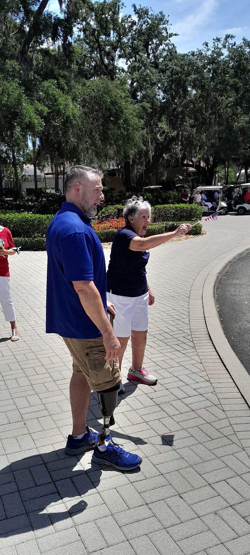 Chris Blauvelt and Deb Kehoe wave to those headed out to play golf.