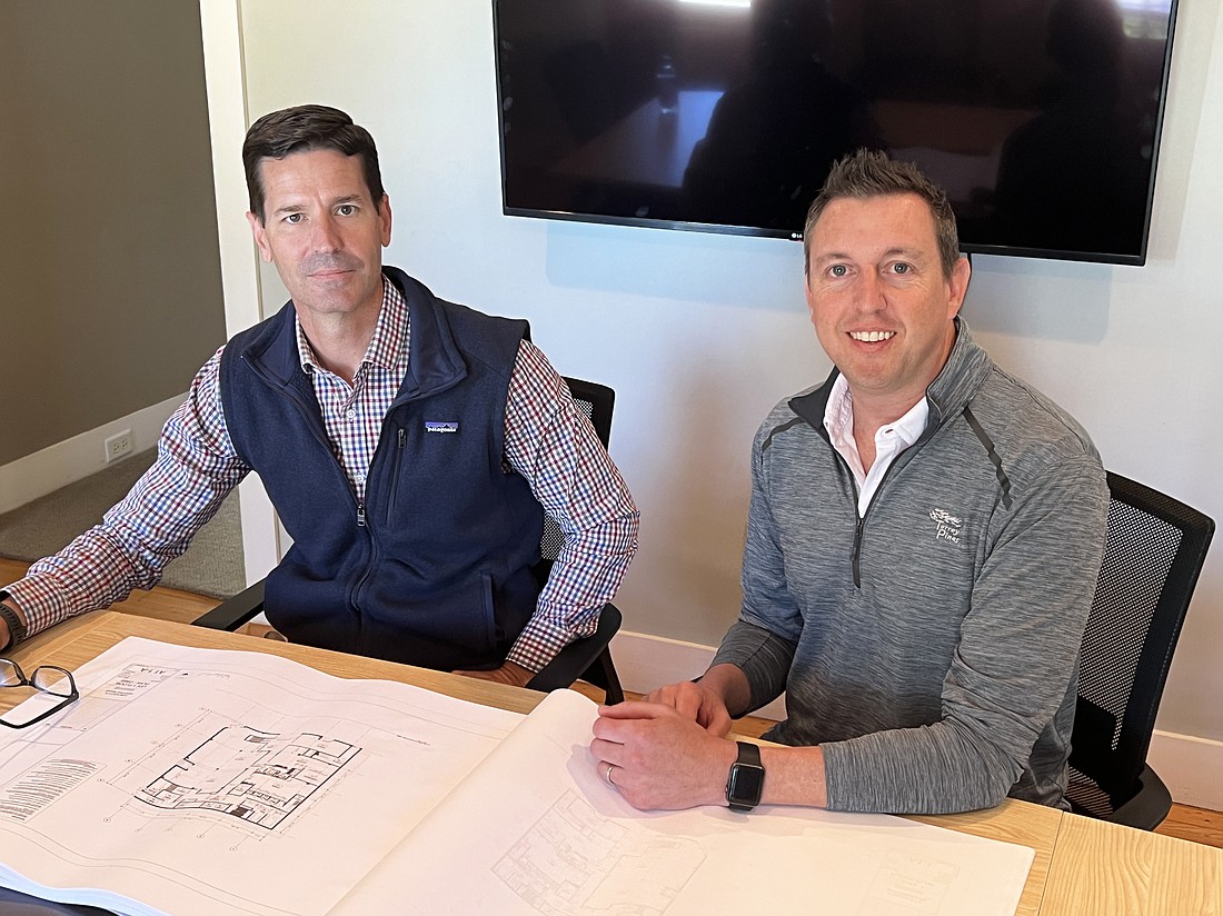 Jason Perry and Joe Grippi look over plans for the renovation of the historic former Furchgott’s Department Store building at 128 W. Adams St. It is one of several Downtown projects by NineOaks Development.