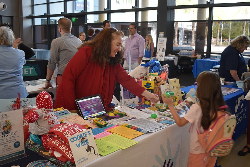 Bonnie Eskell, Early Learning Inclusion Coordinator at Children First, offers an Easter egg to 6-year-old Alina Zambrano.