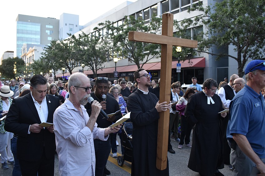 The walk begins with Rev. David Svihel, priest associate for Christian formation and outreach at Church of the Redeemer, carrying the cross, with County Commissioner Joe Neunder (left) also participating.