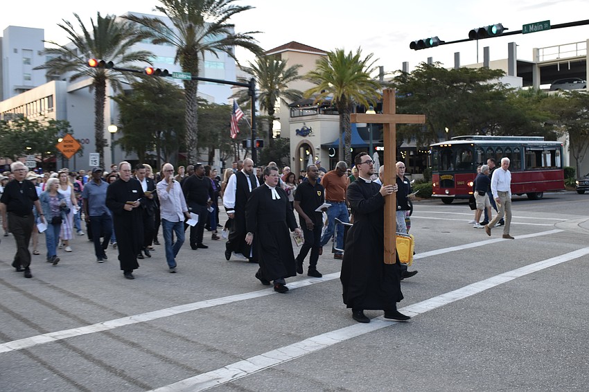 The crowd, led by David Svihel, priest associate for Christian formation and outreach at Church of the Redeemer, crosses South Links Avenue.