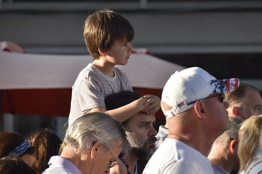 6-year-old Colin Fletcher watches a speaker from the shoulders of his father Ben Fletcher.