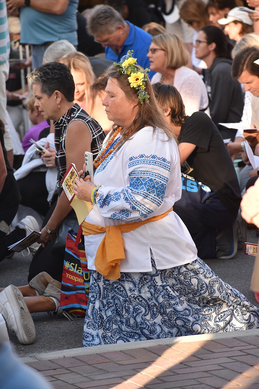 Nadija Packauskas kneels during a prayer.
