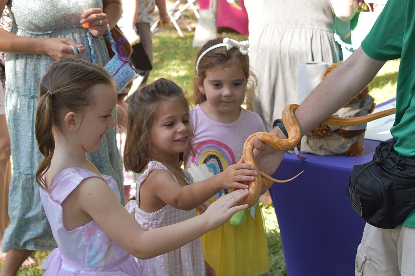 5-year-old Saylor Thompson, 4-year-old Charlotte Snyder, and 5-year-old Amelia Johnson meet a corn snake from Sarasota Jungle Gardens.