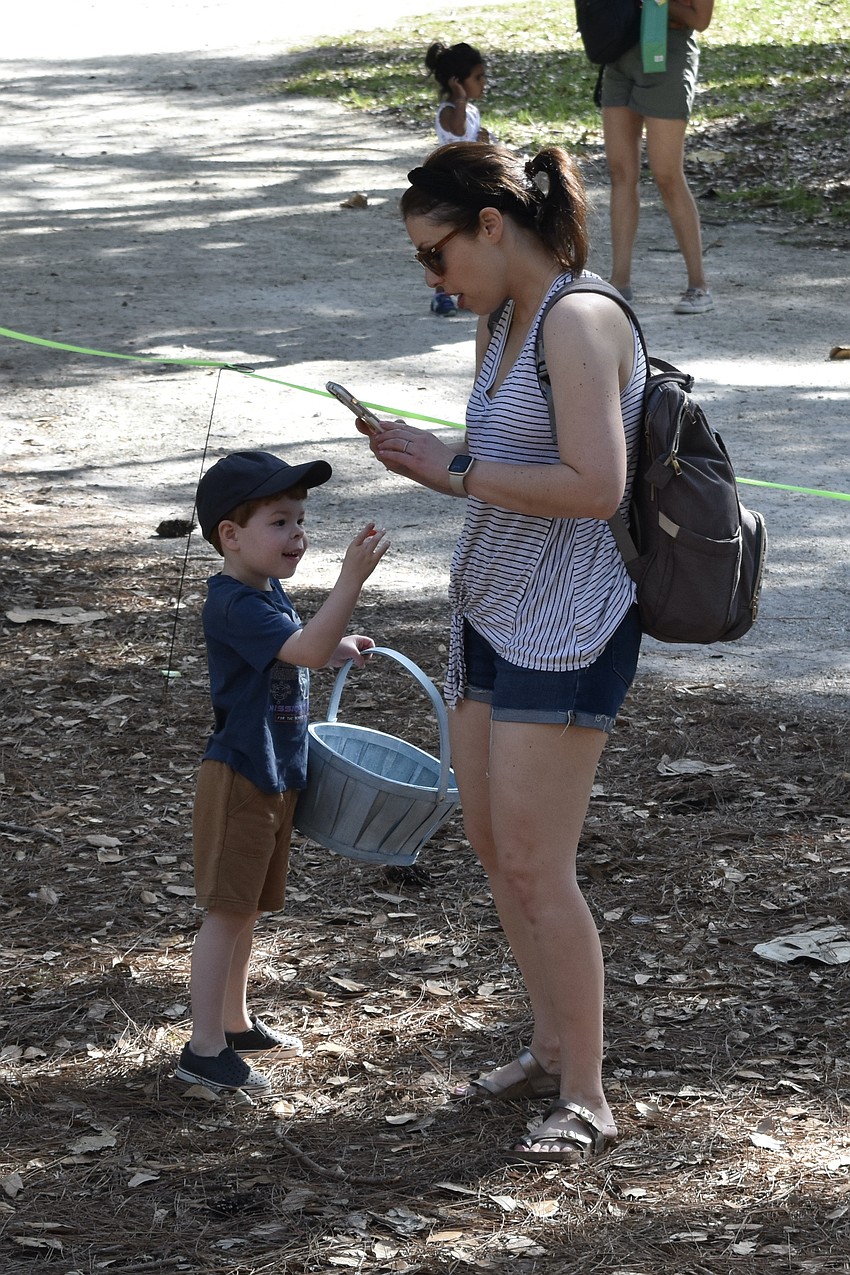 4-year-old Henry Inman shows a toy dinosaur he found in his egg to his mother Melissa Inman.