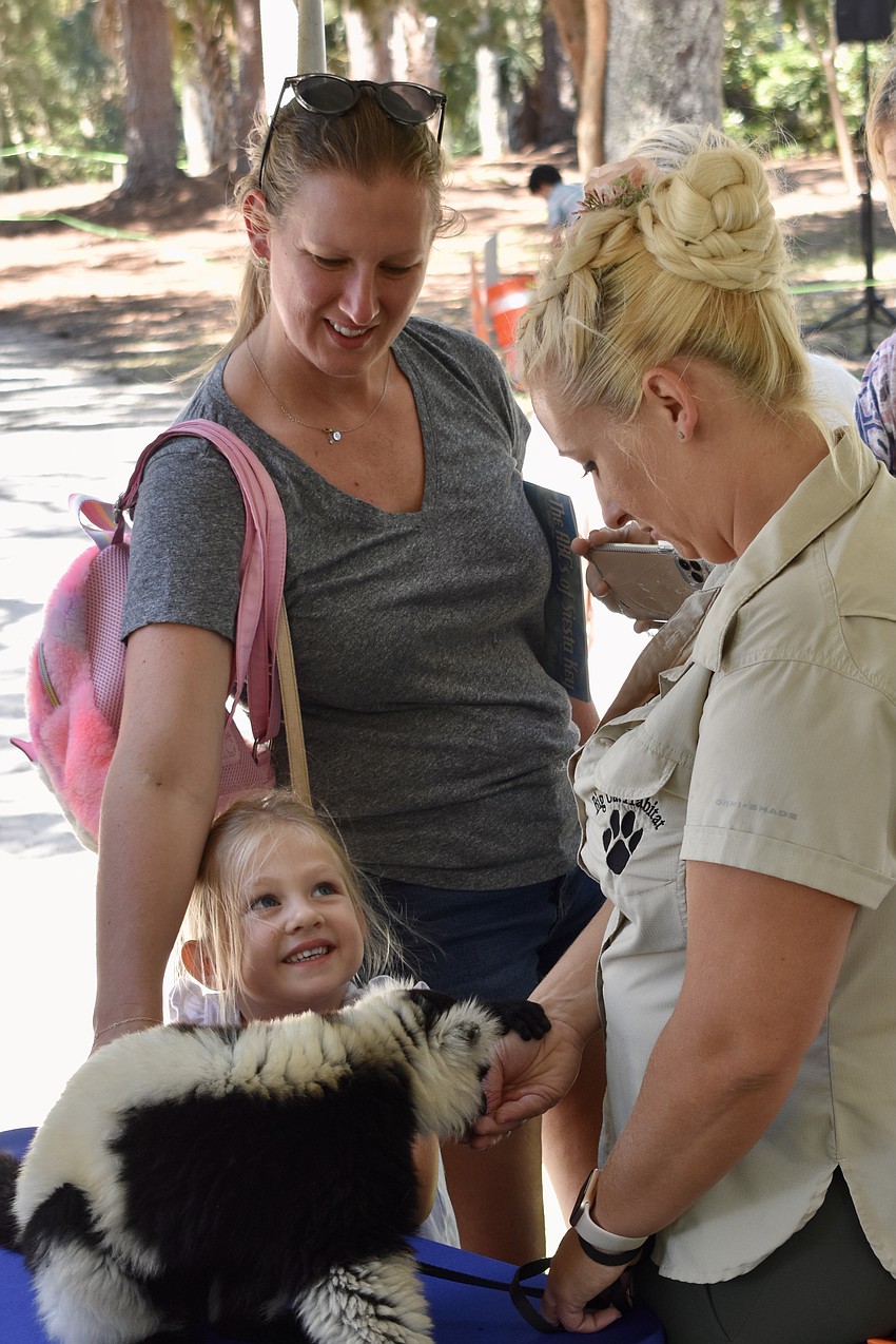 Deva Vaden and 4-year-old Vesper Vaden meet a lemur presented by Cassandra Daly of Big Cat Habitat.