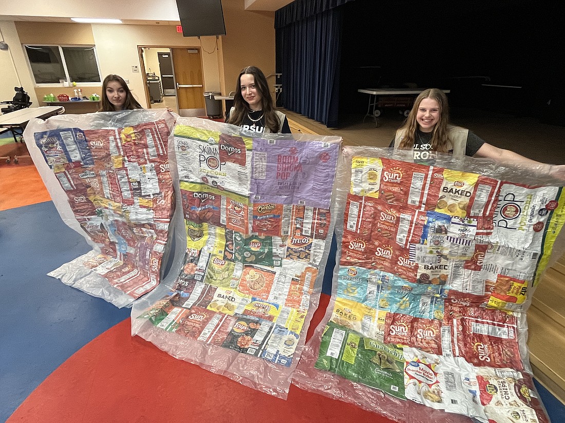 Reese Gurski, Isabella Arteaga and Alice Barr, who are members of Girl Scout Troop 701, create blankets out of chip bags to donate to those who are homeless to earn their Silver Award.