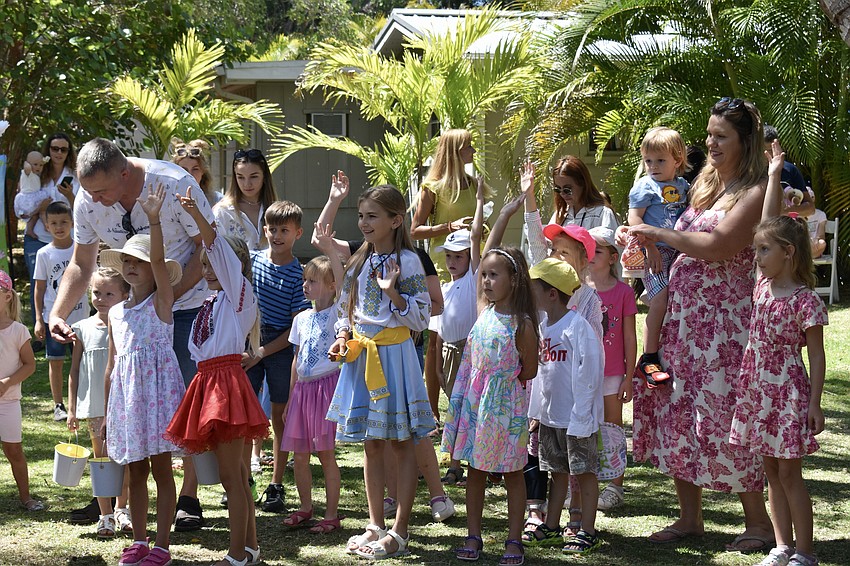The kids raise their hands to play hopscotch.