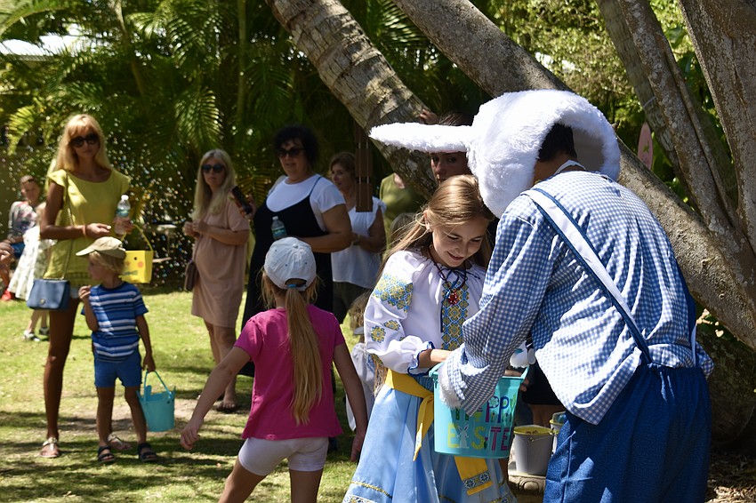After their turn at hopscotch, the kids get a candy from the Easter Bunny.