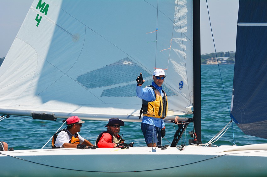 A crew gives a smile and wave as they sail by.