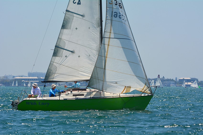 The crew of With Envy sail by on the bay.