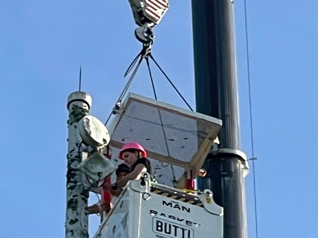 The Nassau County School District, radio communication system. Marissa Marchisillo rose 190 feet in the air on a crane to mount a 25-foot antenna.