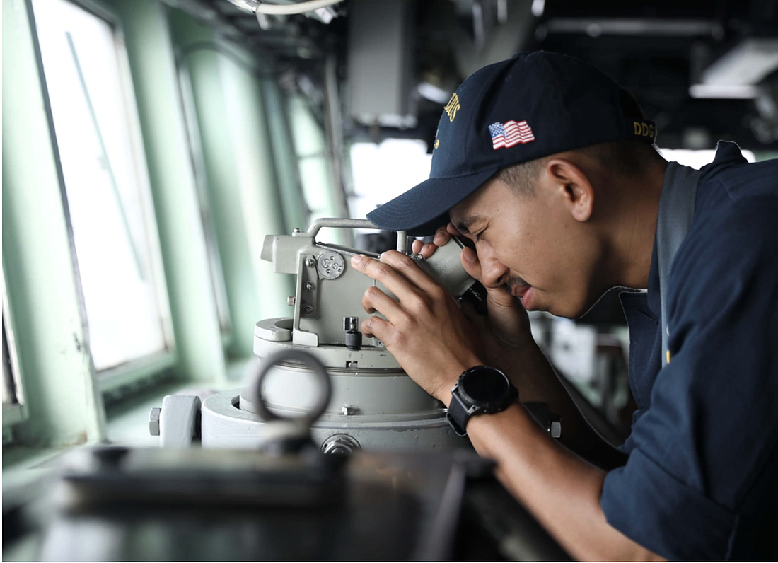Ensign Ryan Le, from Ocoee, looked through a telescopic alidade on the bridge aboard the Arleigh Burke-class guided-missile destroyer USS Milius. Photo by Petty Officer 1st Class Gregory Johnson