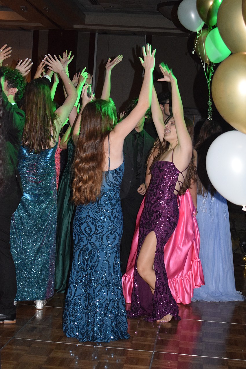 Students throw their hands up in the air and jump to the beat.