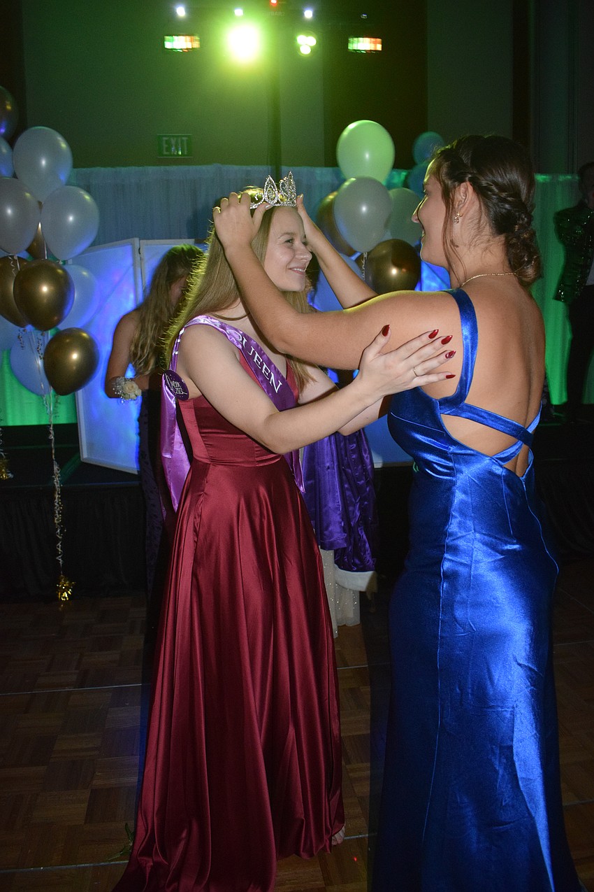 Senior Skylar Cox is crowned prom queen by junior Sophia D'Orazio.
