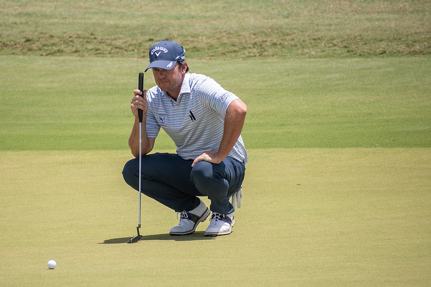 Ryan Blaum examines the green on hole No. 17 at Lakewood National before sinking a birdie putt. Blaum shot four under par Sunday and finished the tournament 14 under par.