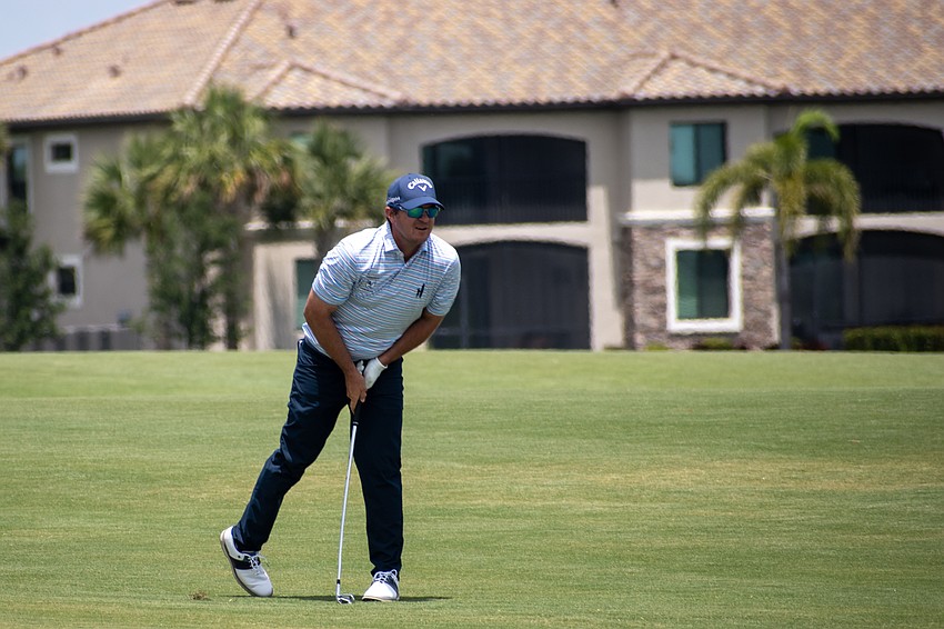 Ryan Blaum hunches over while watching his second shot on the No. 18 hole at Lakewood National. Blaum shot four under par Sunday and finished the tournament 14 under par.